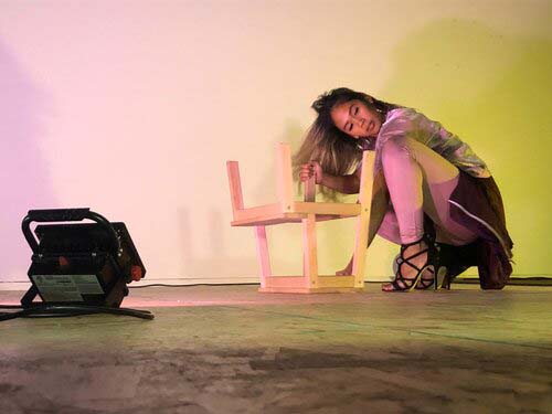 Danah Rosales crouching in front of a stool