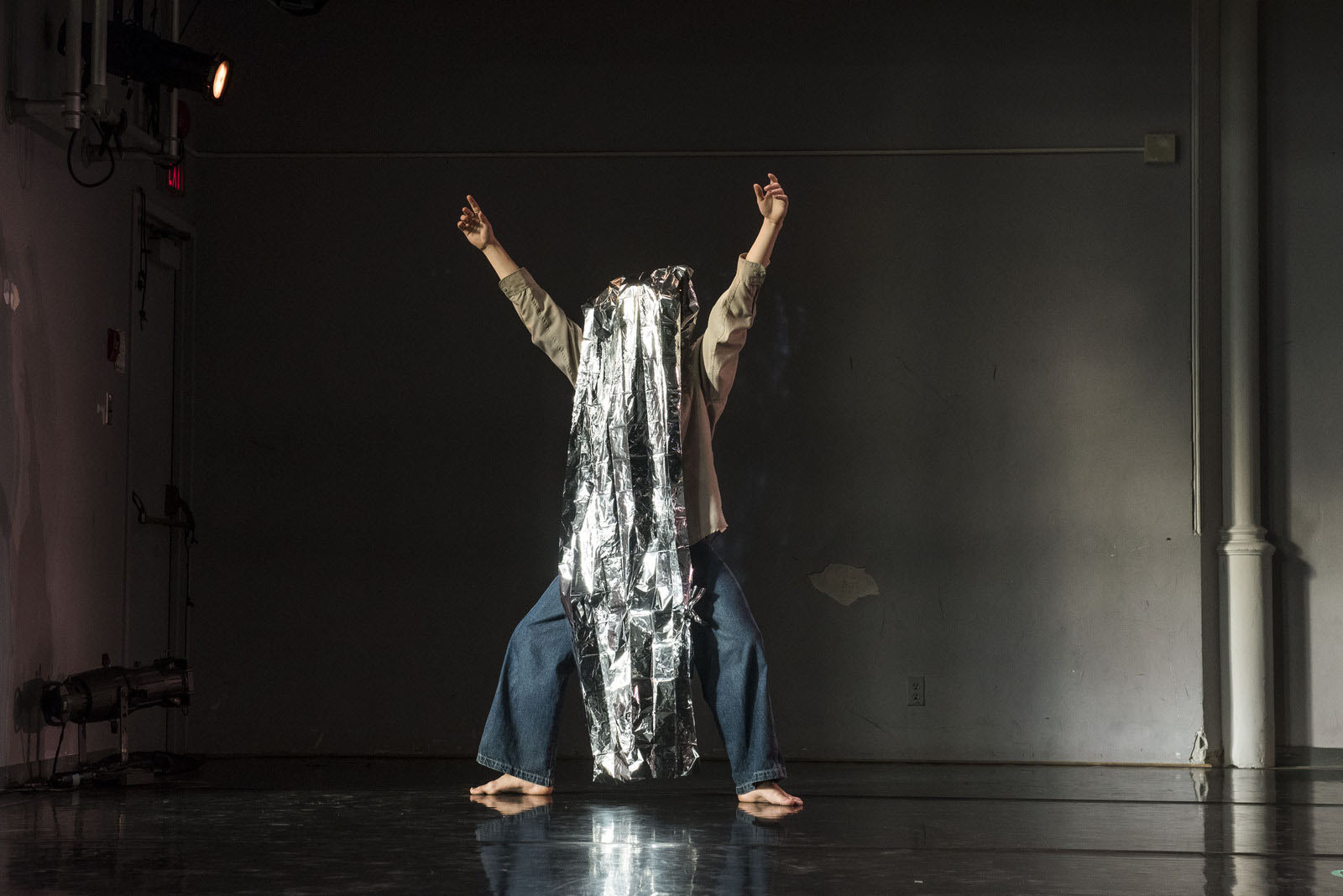 Performer standing with shiny fabric over their head.