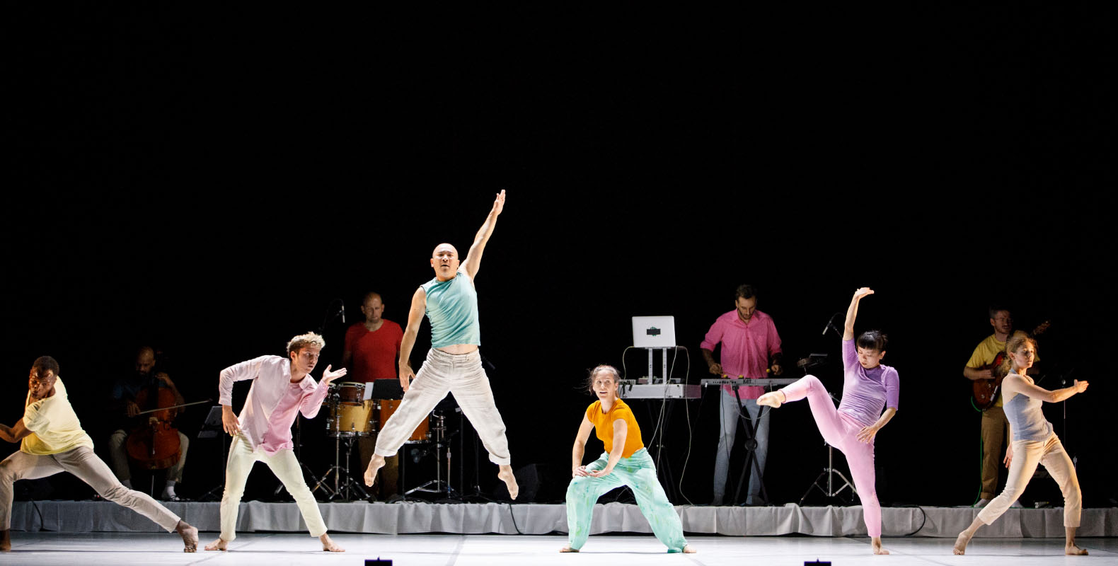 Performers on stage dancing in a variety of poses