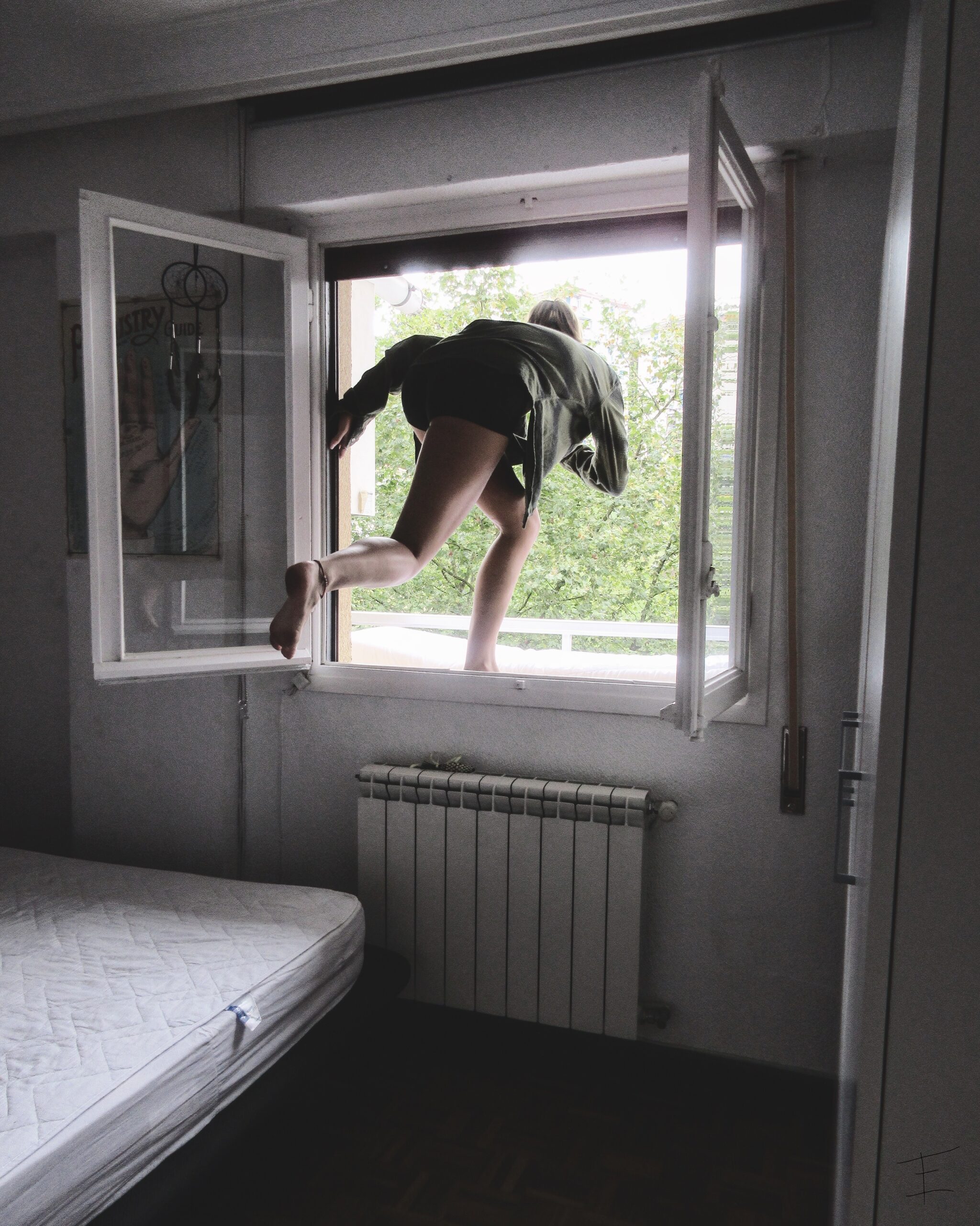 Emily is stepping on an open window ledge from a bedroom, as if she's about to lunge off into the outdoors.
