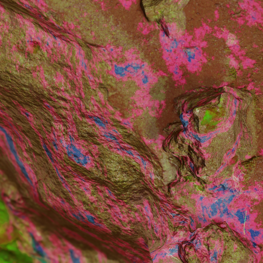 A 3-D close-up image of a rock with bright pink and blue paint-like splatters across it.