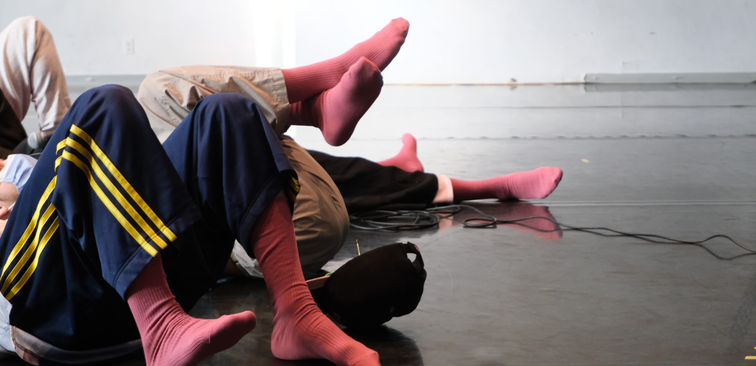 Dancers legs on the floor with colourful pink socks